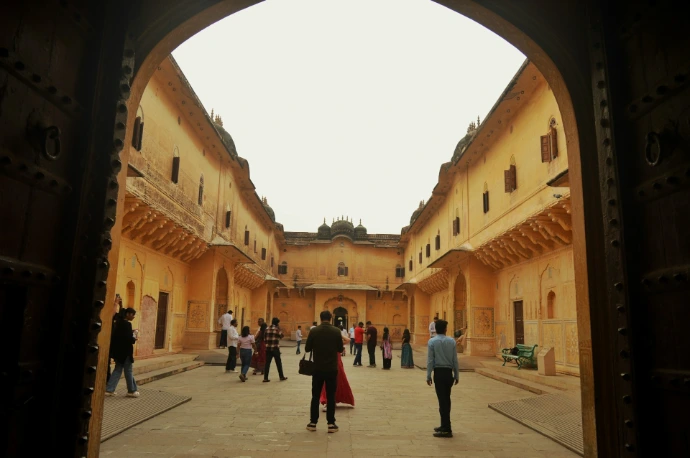 People explore a historic courtyard and entrance.